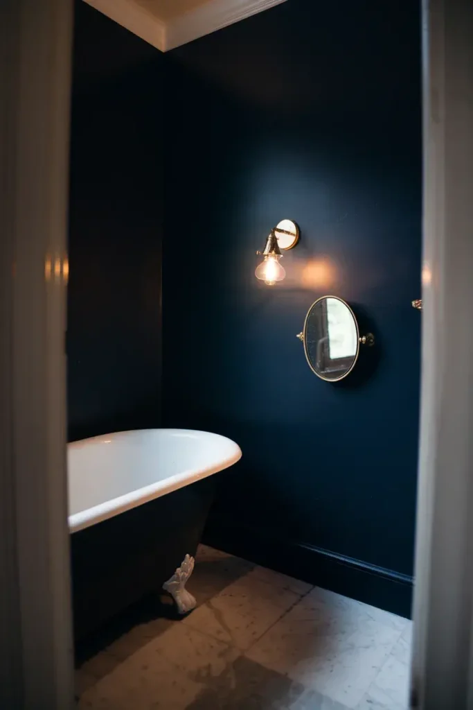 deep blue bathroom clawfoot tub brass sconce