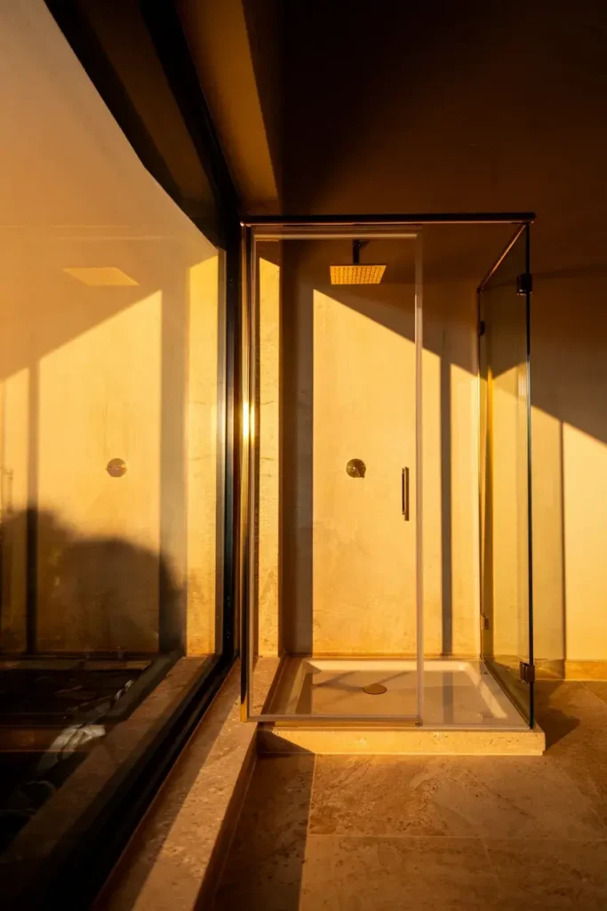 glass shower brass frame golden hour light
